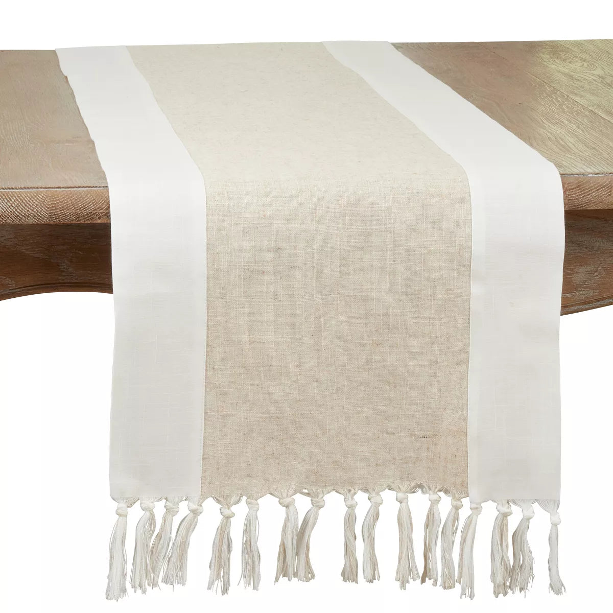 Beige and white table runner with tassels on a wooden table
