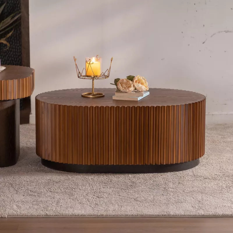 Wooden coffee table with a textured surface, featuring a book and flowers on top.