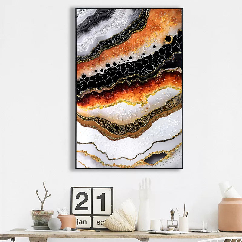 Abstract art print with orange, black, and white colors on a white wall above a desk.