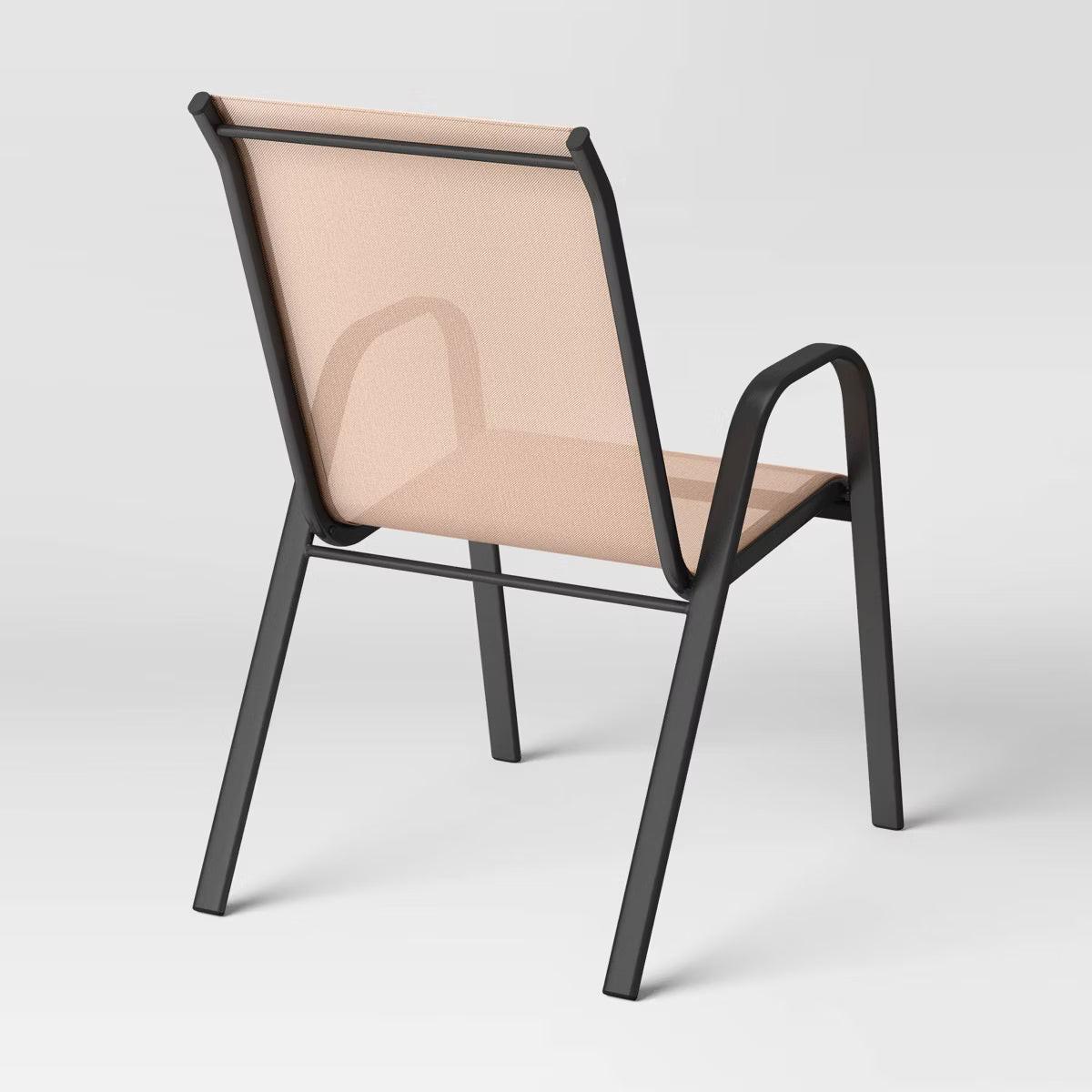 A chair with a beige colored fabric seat and backrest, featuring a black colored metal frame and armrests