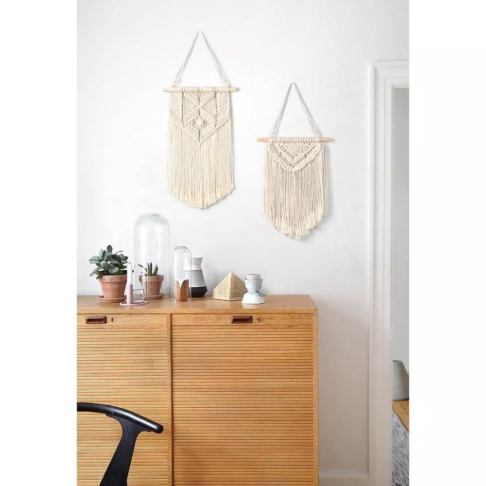 Macrame wall hanging with geometric pattern on a white background