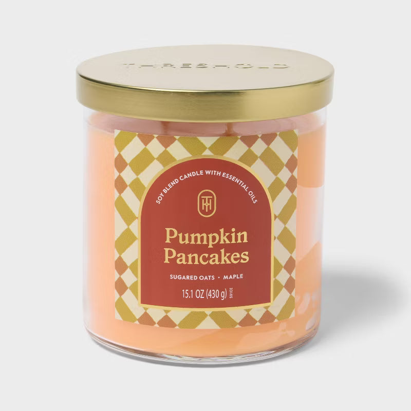 Candle labeled 'Pumpkin Pancakes' on a marble surface with a vase and tray in the background 15.1oz