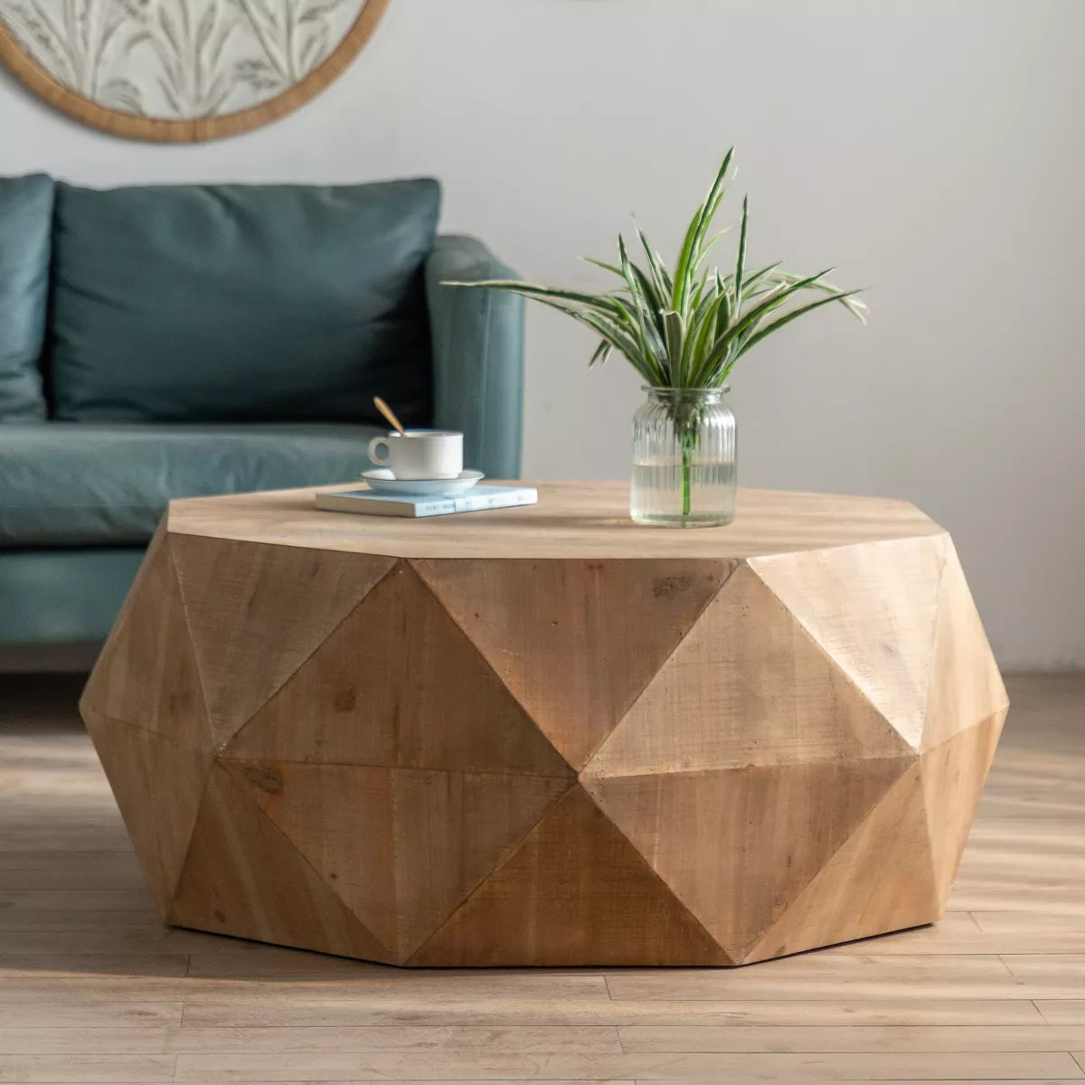 Hexagonal wooden coffee table with a cup, saucer, and flowers on a wooden floor.