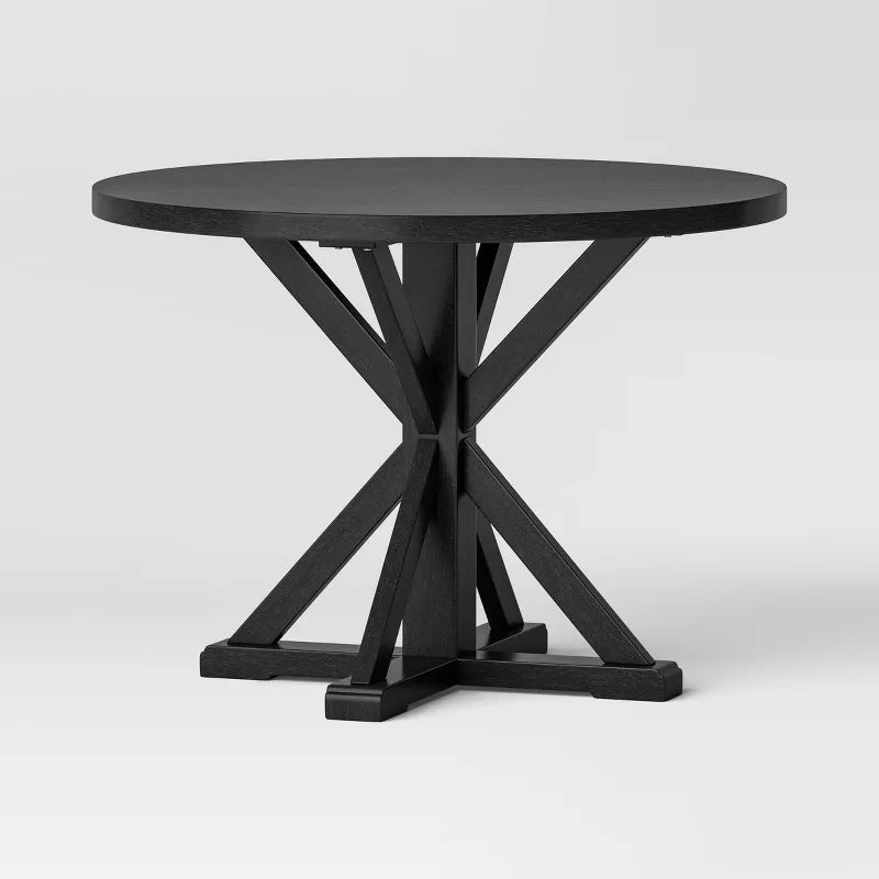 Black round table with a unique base design on a white background