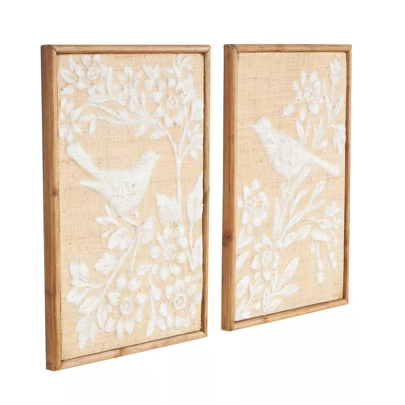 Two framed wall art pieces with white floral and bird designs on a beige background.
