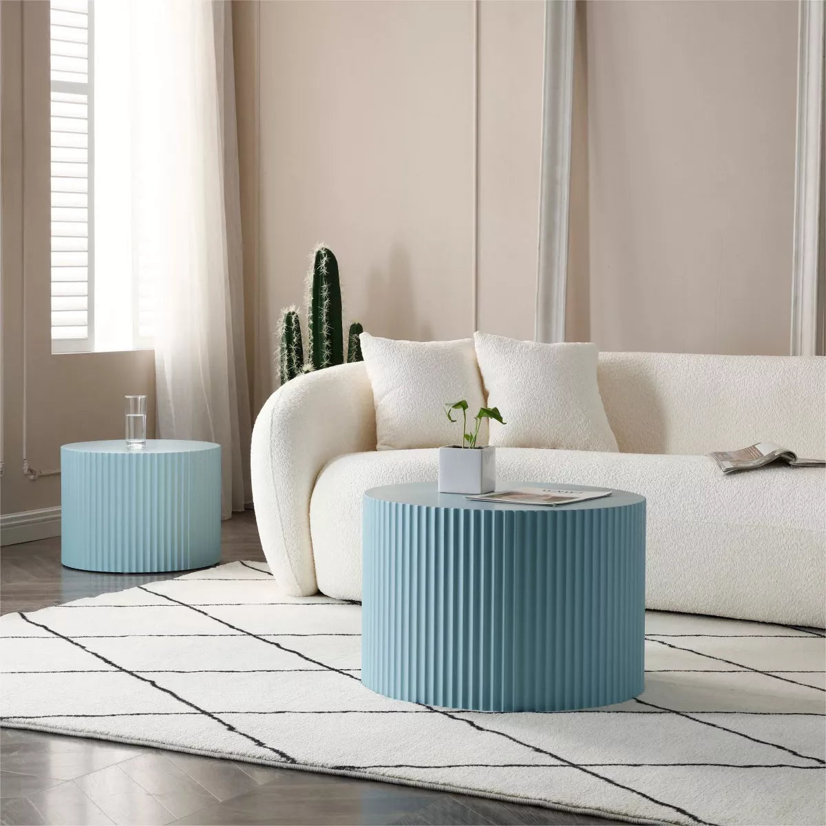 Blue ribbed side table with a magazine on top, featuring a plant and white vase.blue