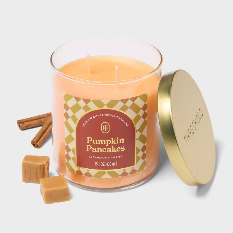 Candle labeled 'Pumpkin Pancakes' on a marble surface with a vase and tray in the background 15.1oz
