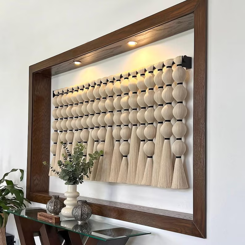 Decorative wall art with wooden frame and geometric design on a white wall.