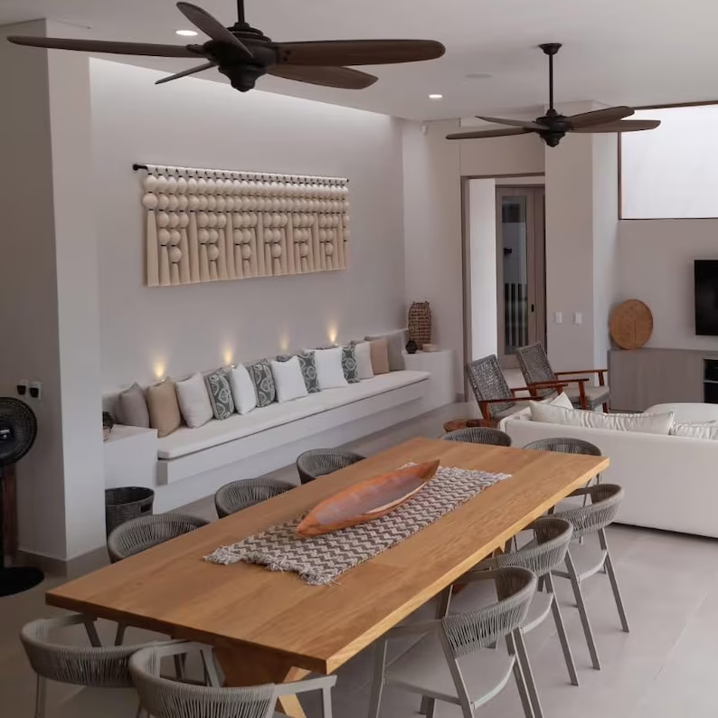 Modern living room with a wooden dining table and white sofas.