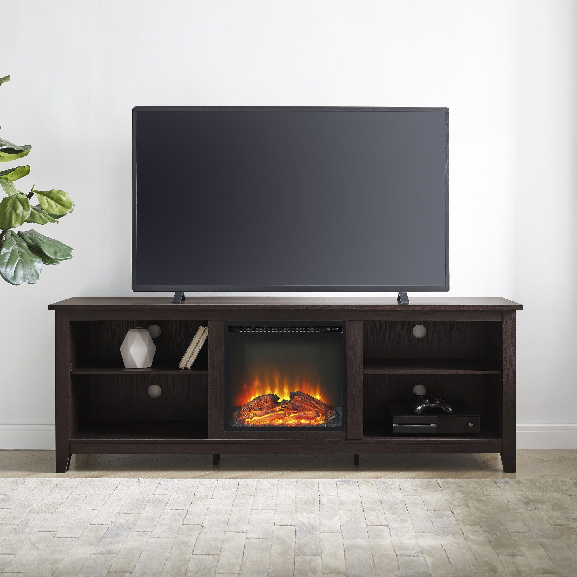 TV on a wooden stand with electric fireplace feature in a room.