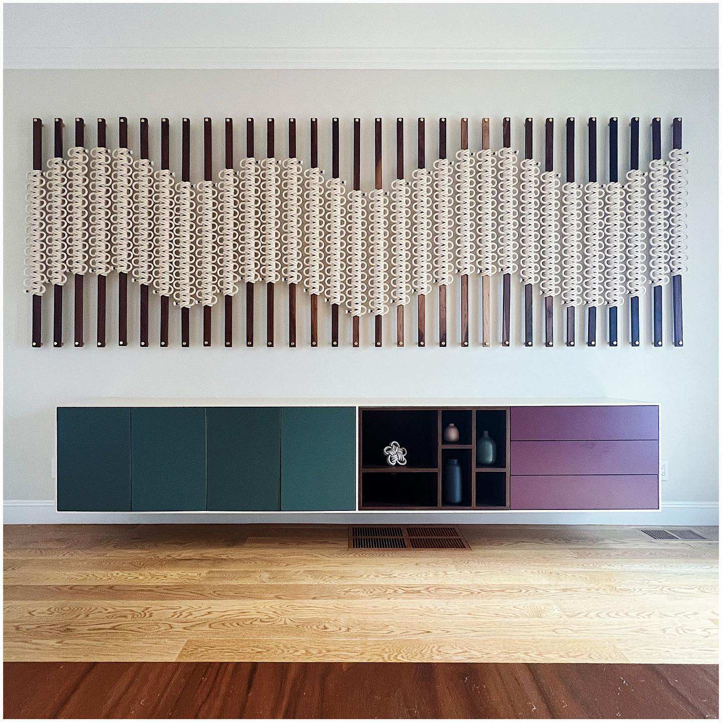 Modern radiator with decorative cover on a wall above a piece of furniture.