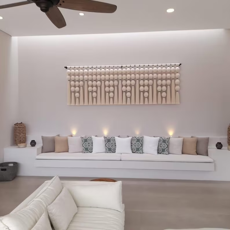 Modern living room with a white sofa, decorative pillows, and wall art.