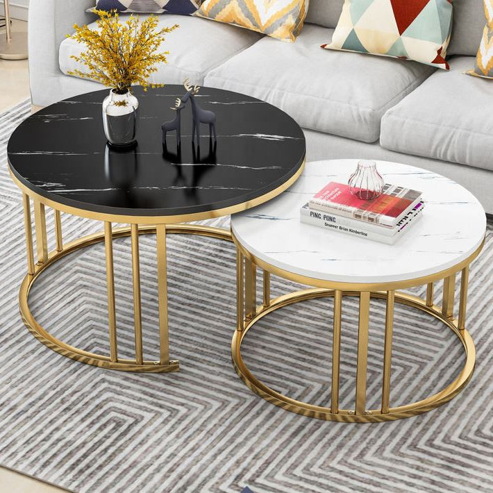 Two round coffee tables with gold frames on a patterned rug, with a sofa and decorative pillows in the background black White