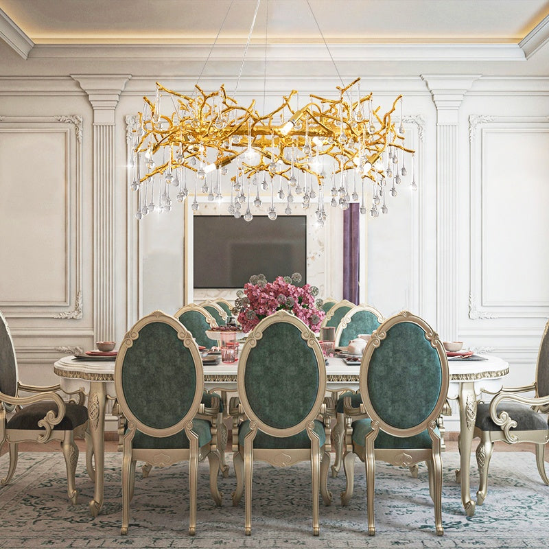 Luxurious dining room with gold chandelier, green chairs, and a table.