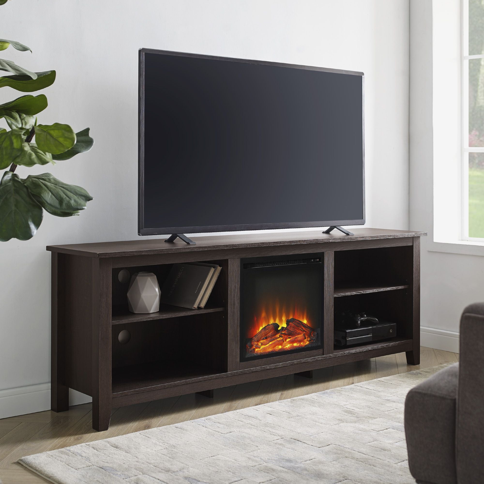 TV on a wooden stand with an electric fireplace display in a living room setting.