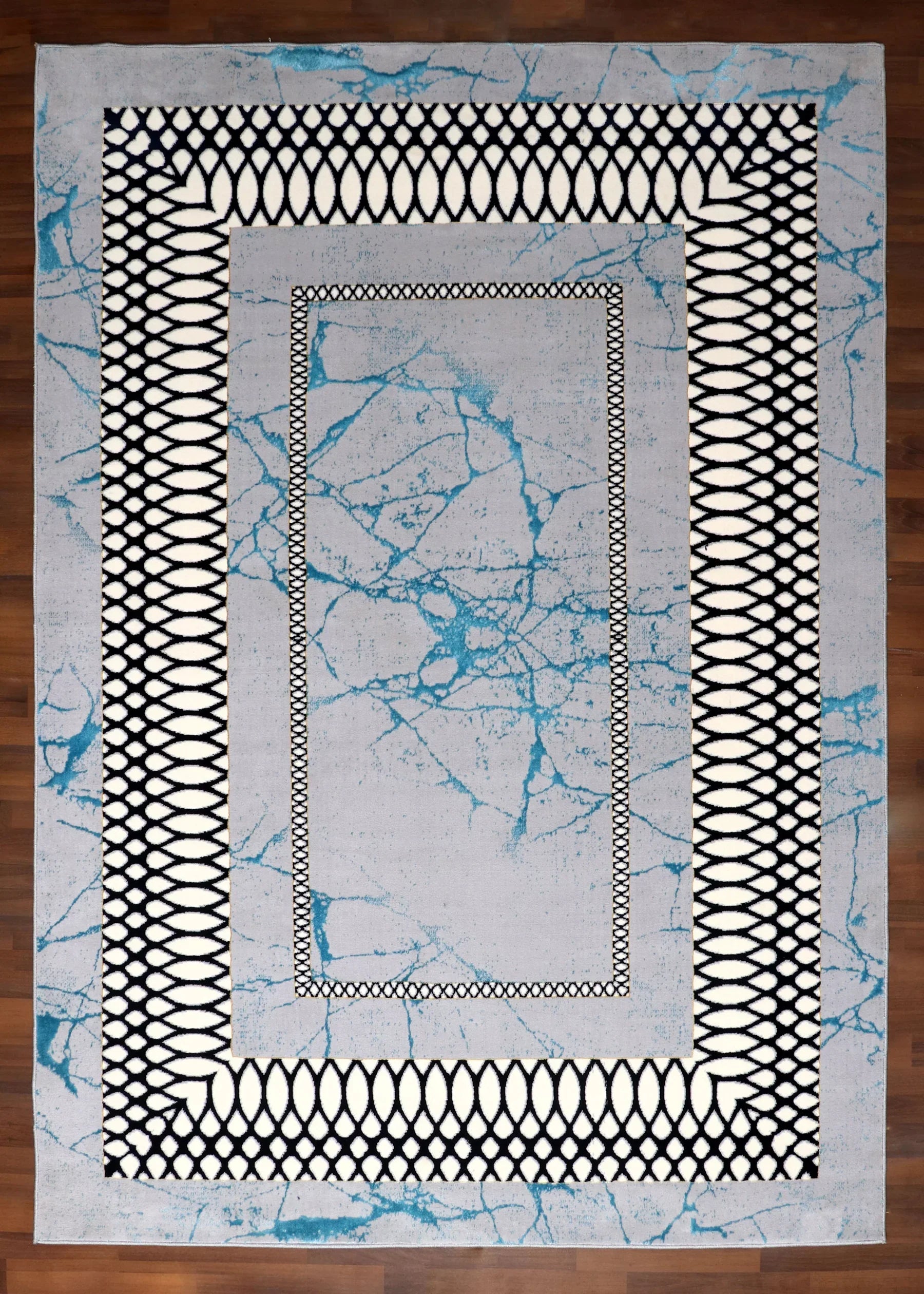 Close-up of a rug with geometric patterns on a wooden floor.