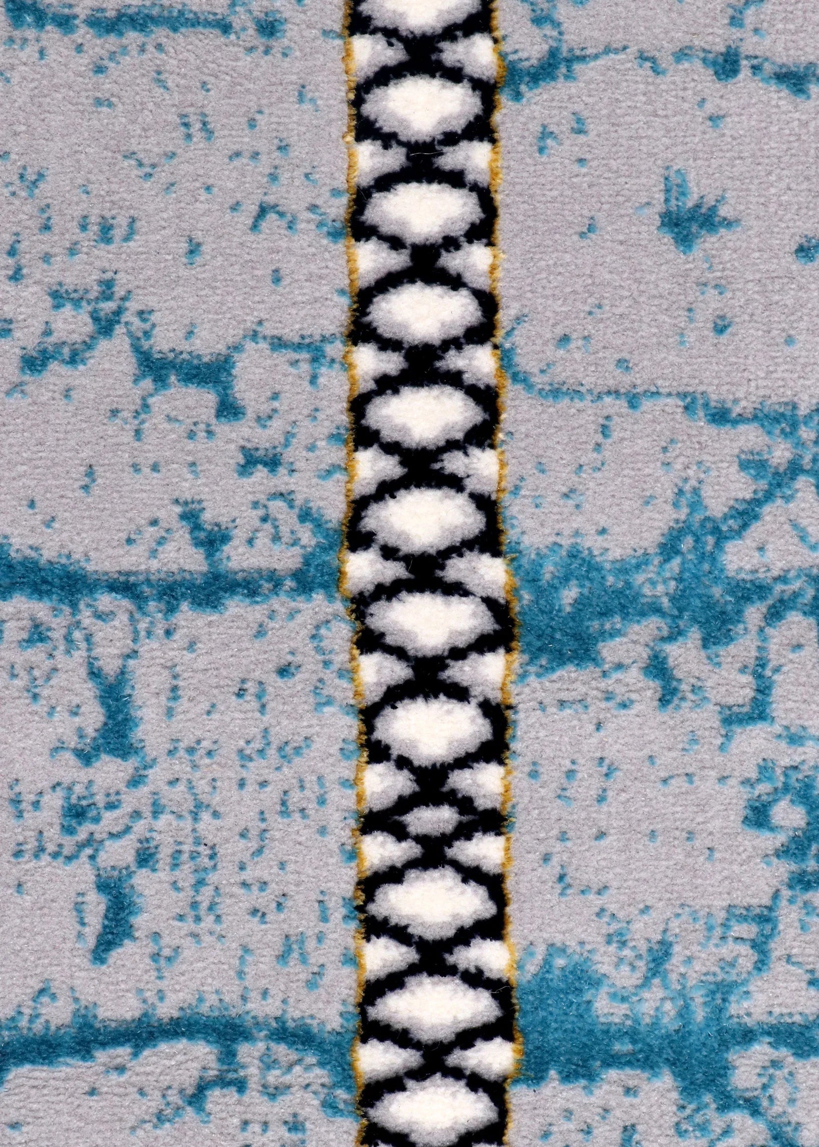 Close-up of a rug with geometric patterns on a wooden floor.