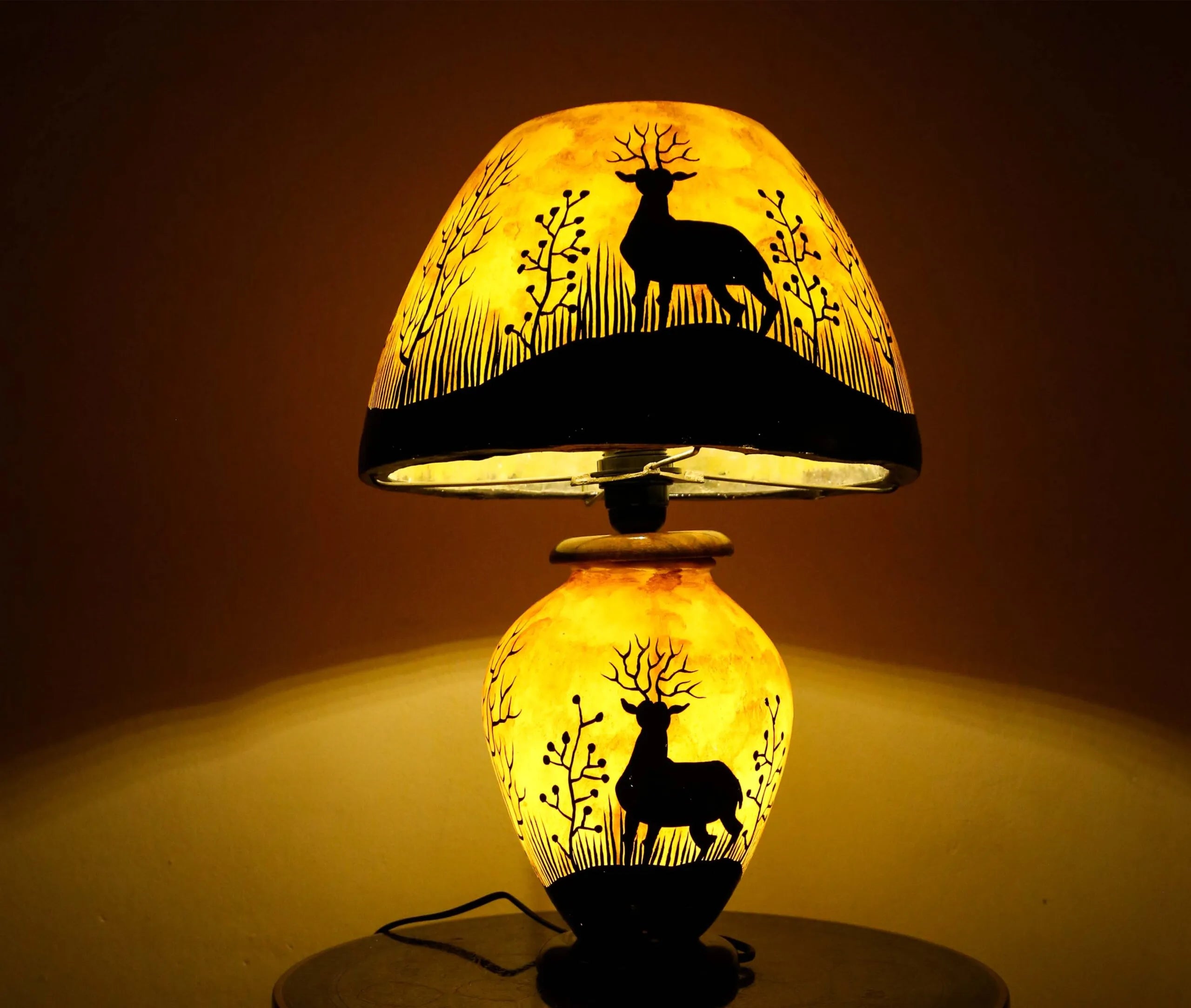 Decorative lamp with deer silhouette design on a dark background