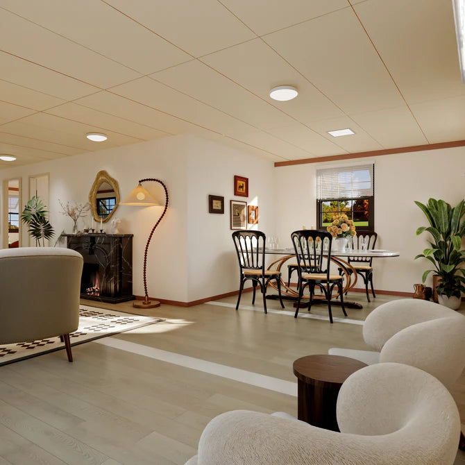 A bright, modern interior room with light wood flooring, cream walls, a fireplace with a black marble mantel, a curved floor lamp, a dining set with black spindle-back chairs, and plush cream upholstered seating in the foreground.