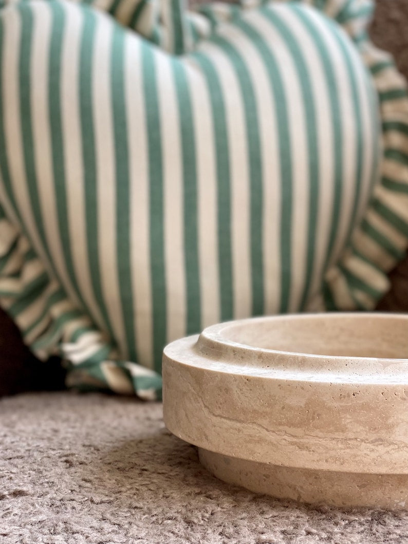 Wooden bowl on a textured surface with striped fabric in the background