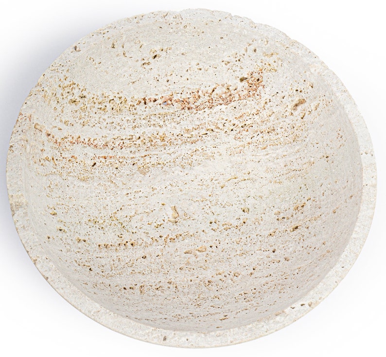 Round stone-like object with a textured surface on a white background
