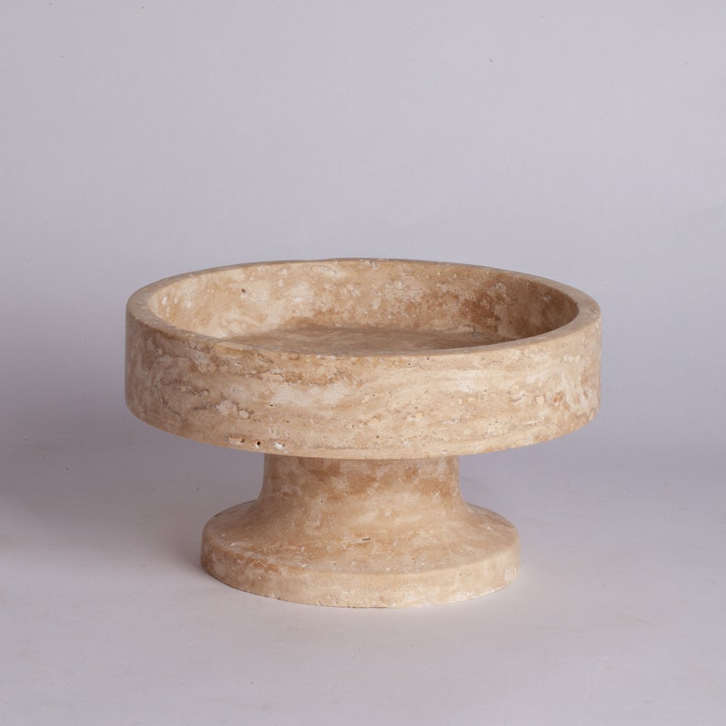 Beige stone pedestal bowl on a light gray background